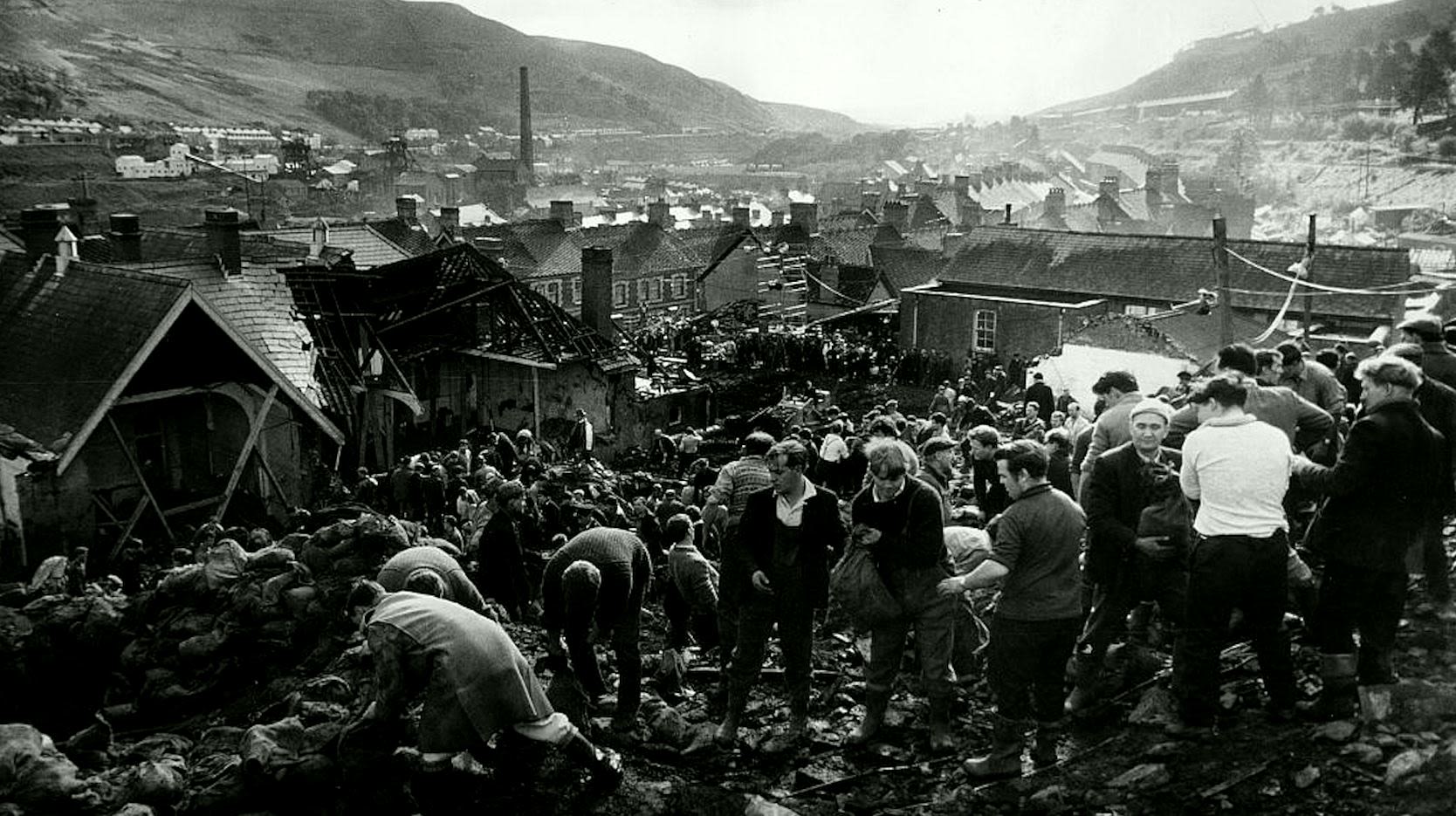 Locals search through a mountain of coal waste that engulfed a school in 1966.