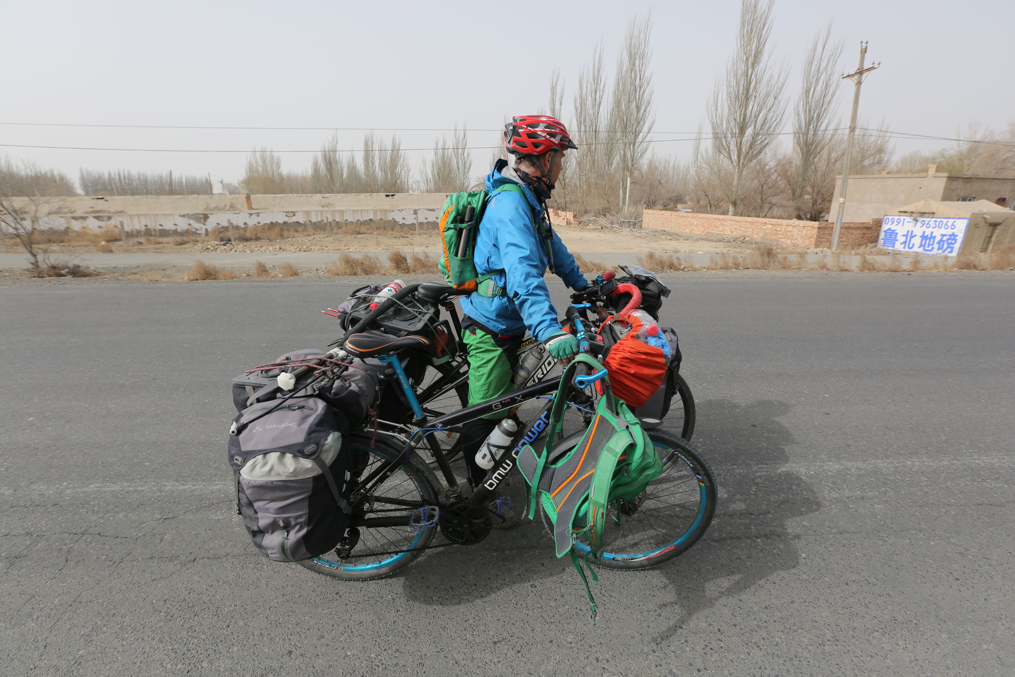 Between Hami and Turpan in Xinjiang, holding Phil Behan's bike during a photocall.