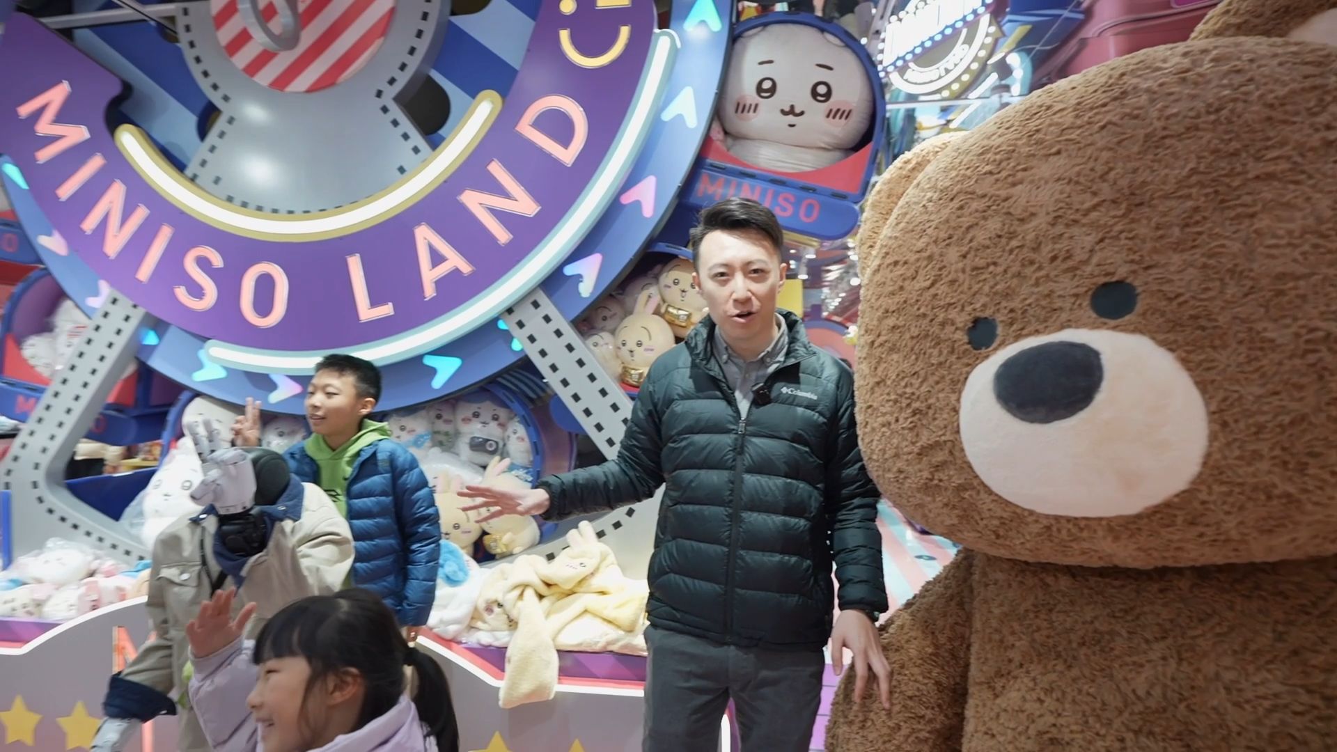 A child poses with Miniso's robot, while CGTN's Tianyu stands with the store's longterm mascot.
