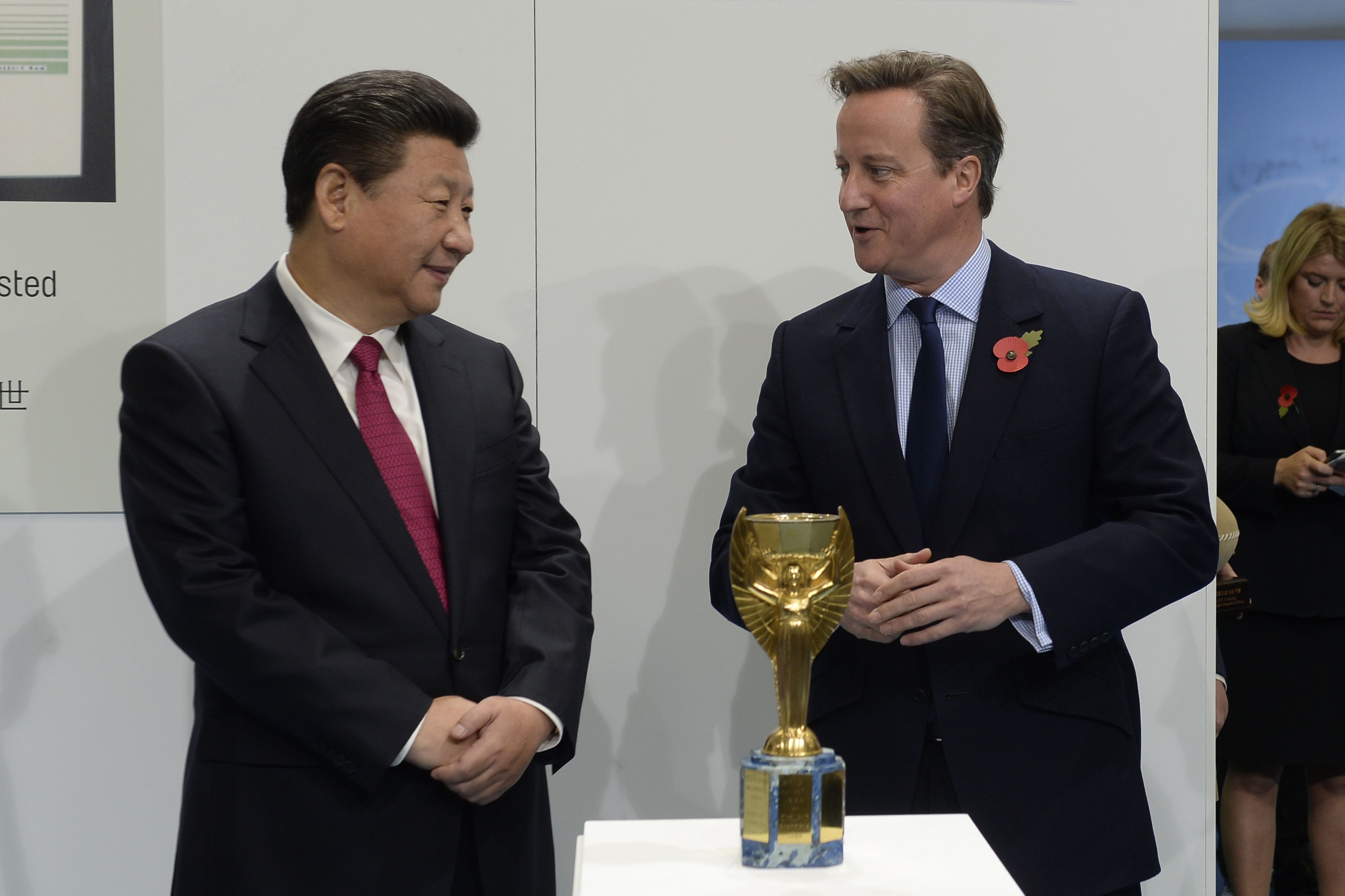 Xi Jinping and then UK PM David Cameron admire football's former World Cup trophy in 2015. /Joe Giddens/Pool/AP