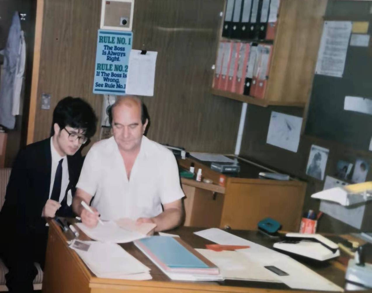 The young Liu Baocheng (left) signing shipping documents with a captain for exporting goods to Rotterdam in 1988.