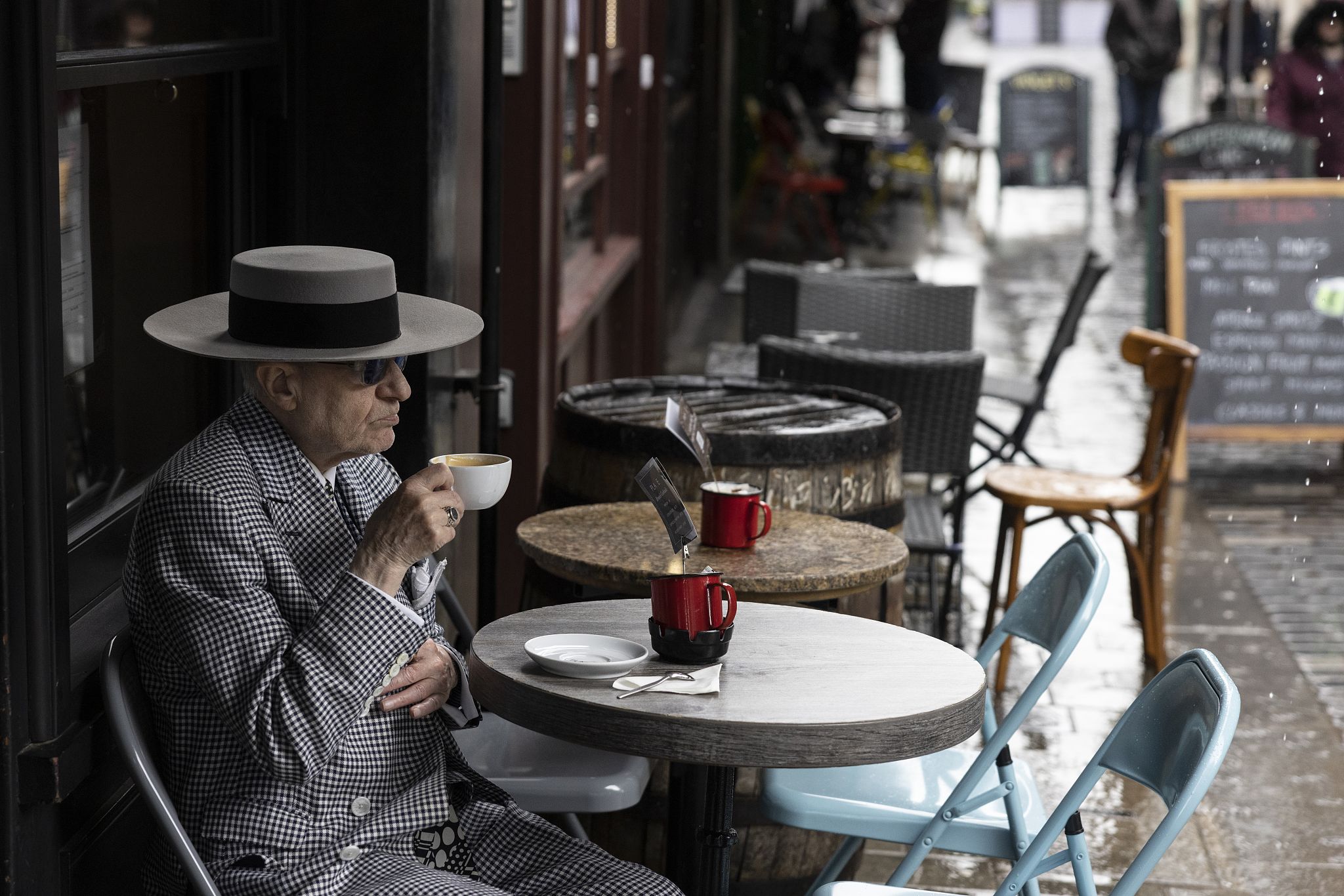 A man drinks a coffee as cafes reopen in Soho, London.