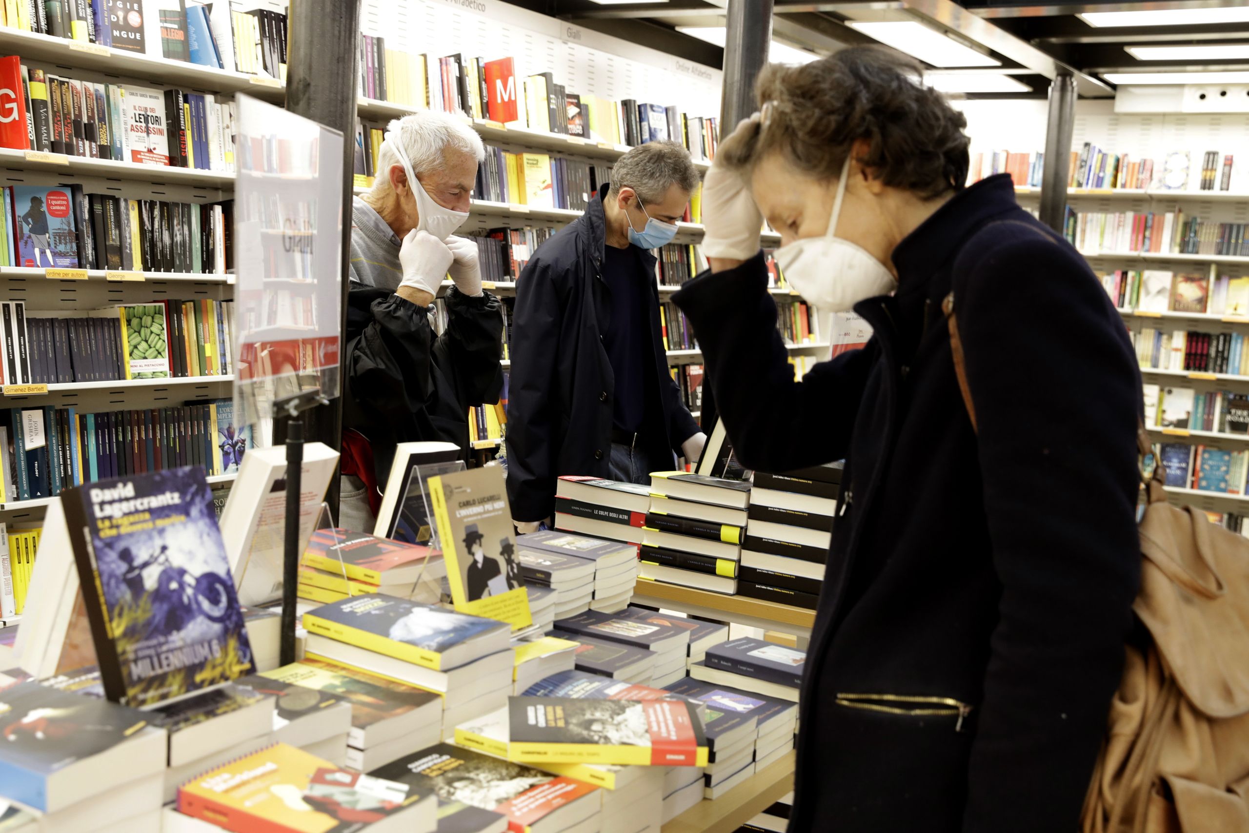 People wearing face masks browse in a Rome bookstore.