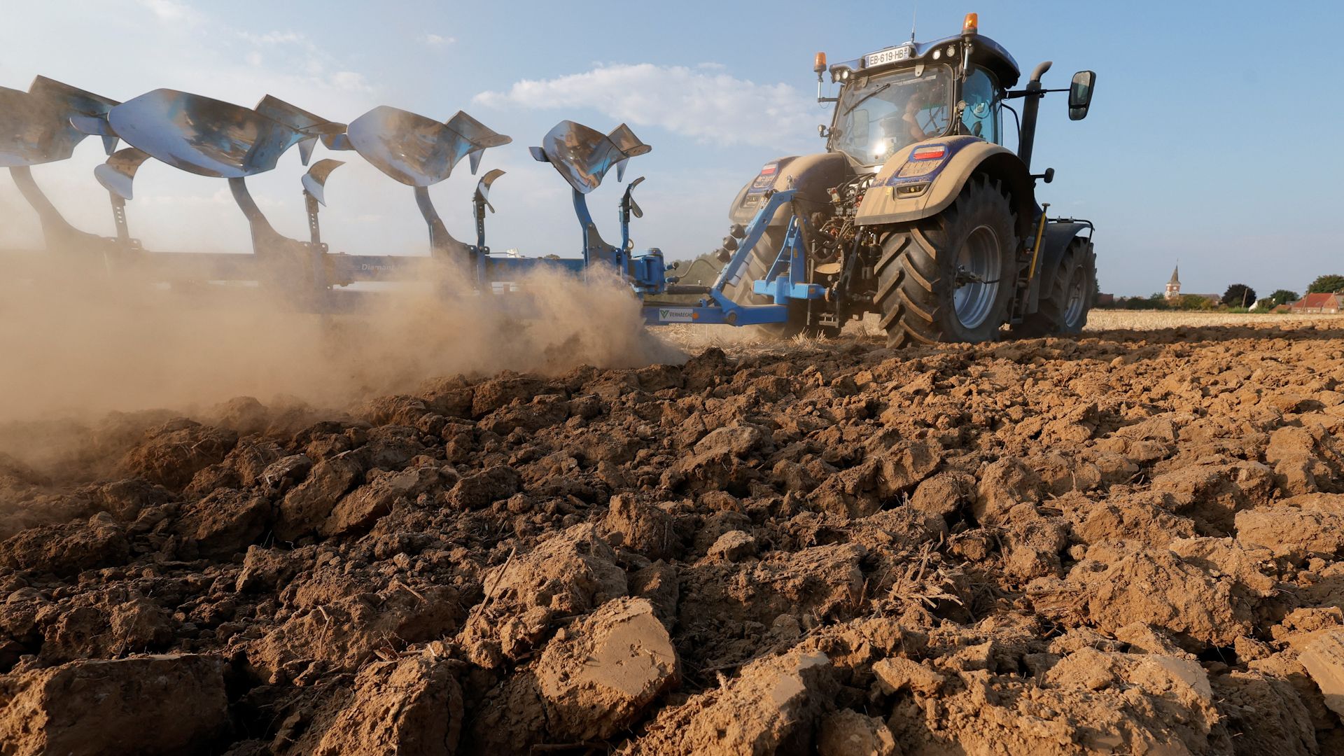 A farmer drives a tractor across a parched field in north-eastern France.