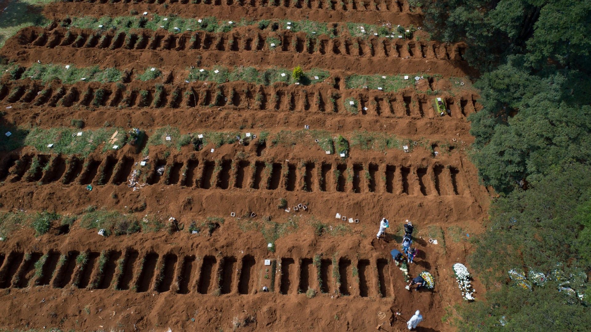 Cemetery workers in protective clothing bury a body at the Vila Formosa cemetery in Sao Paulo, Brazil.