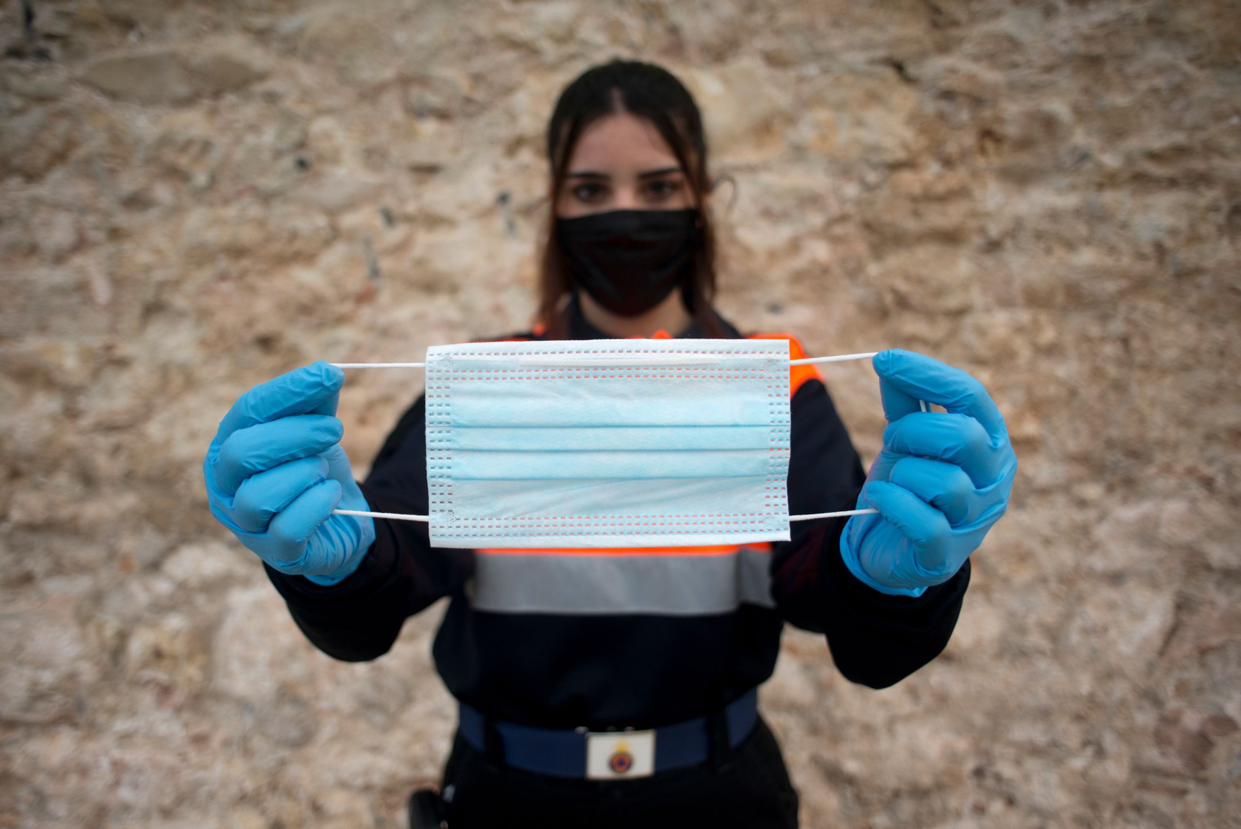 A Spanish Civil Protection member poses with a face mask.